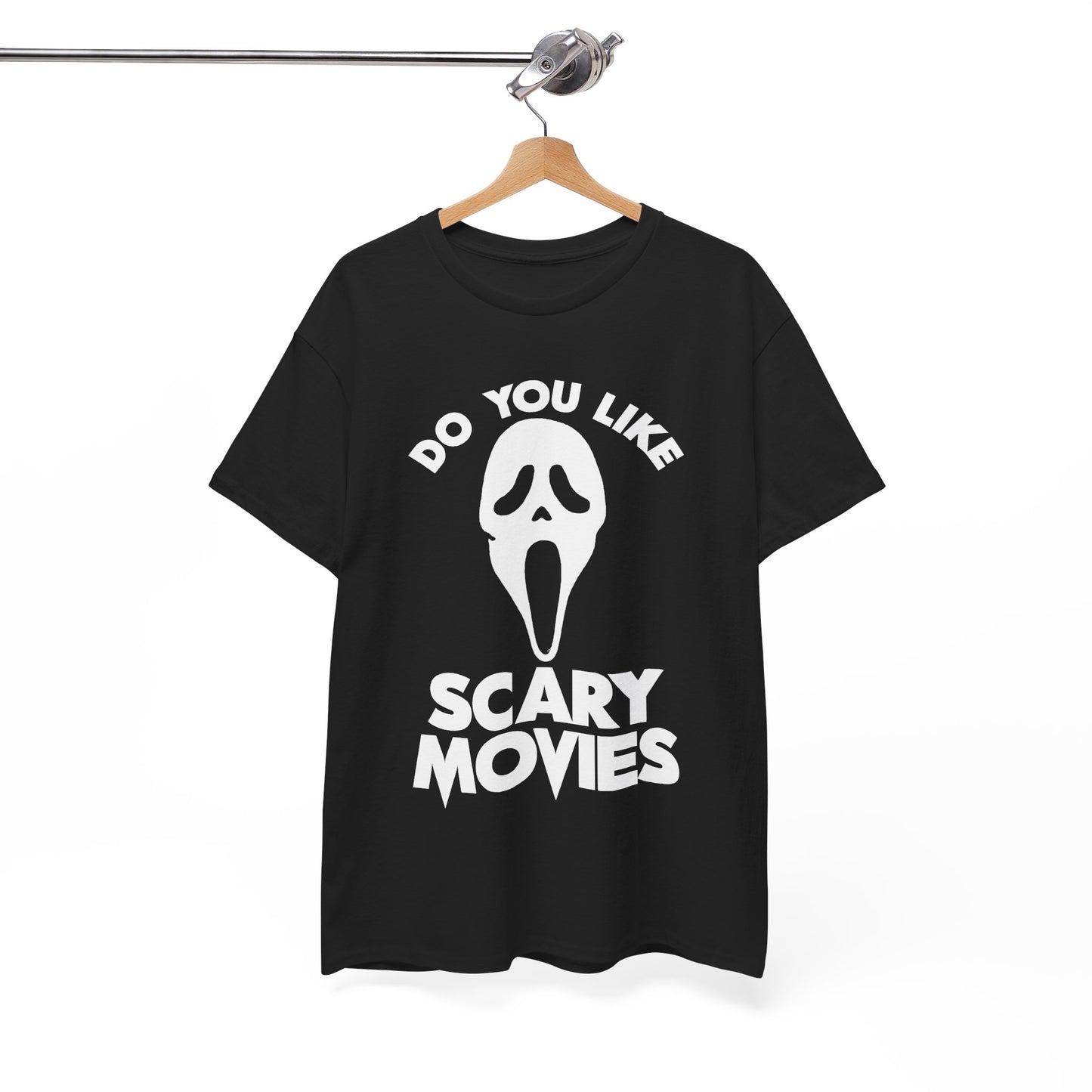 A black short-sleeve t-shirt hanging on a wooden hanger from a metal rail, featuring a white graphic of the Ghostface mask with the text 'DO YOU LIKE SCARY MOVIES' printed on the front.