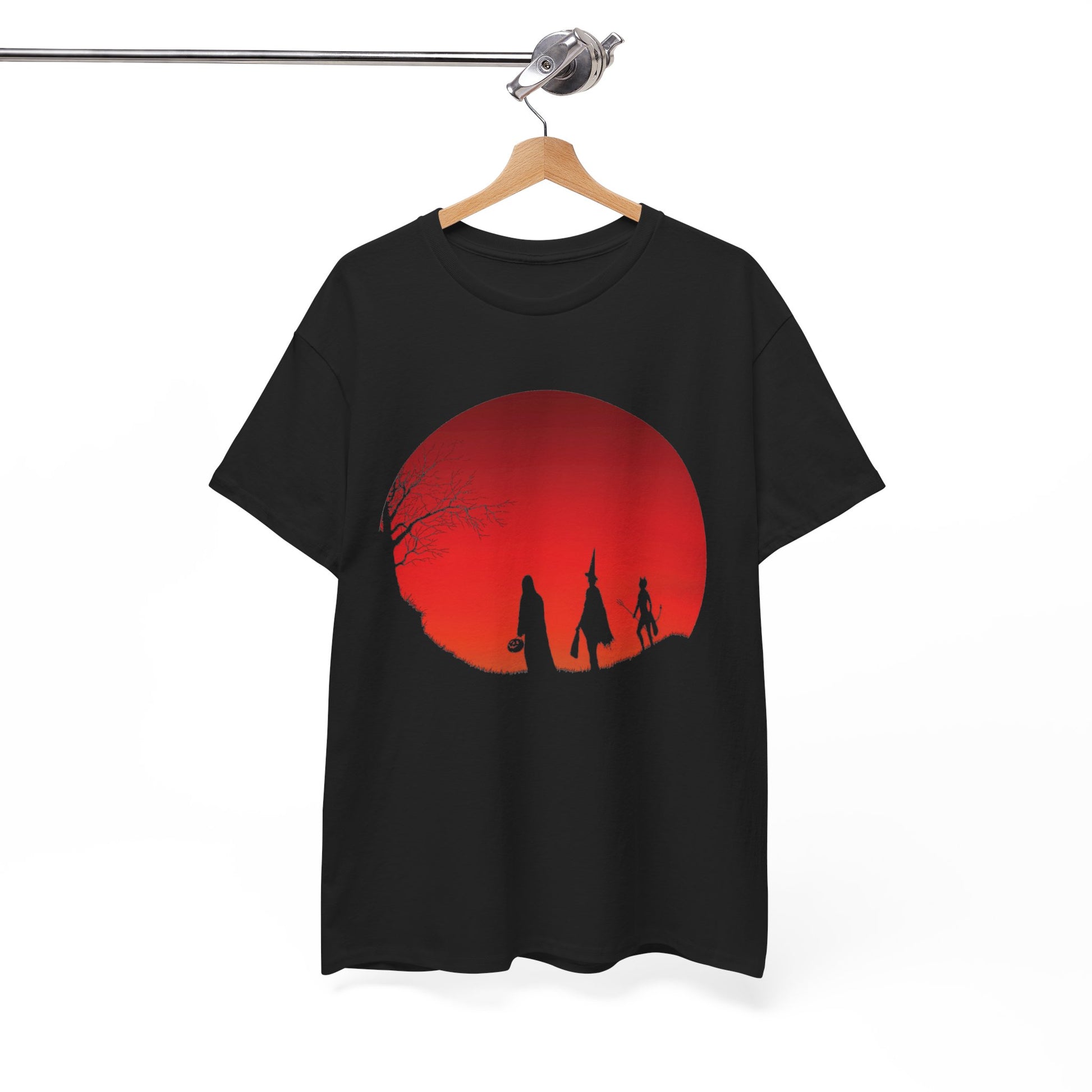 A black short-sleeve t-shirt hanging on a wooden hanger from a metal rod, featuring a graphic print of a large red full moon with black silhouettes of figures and a bare tree.