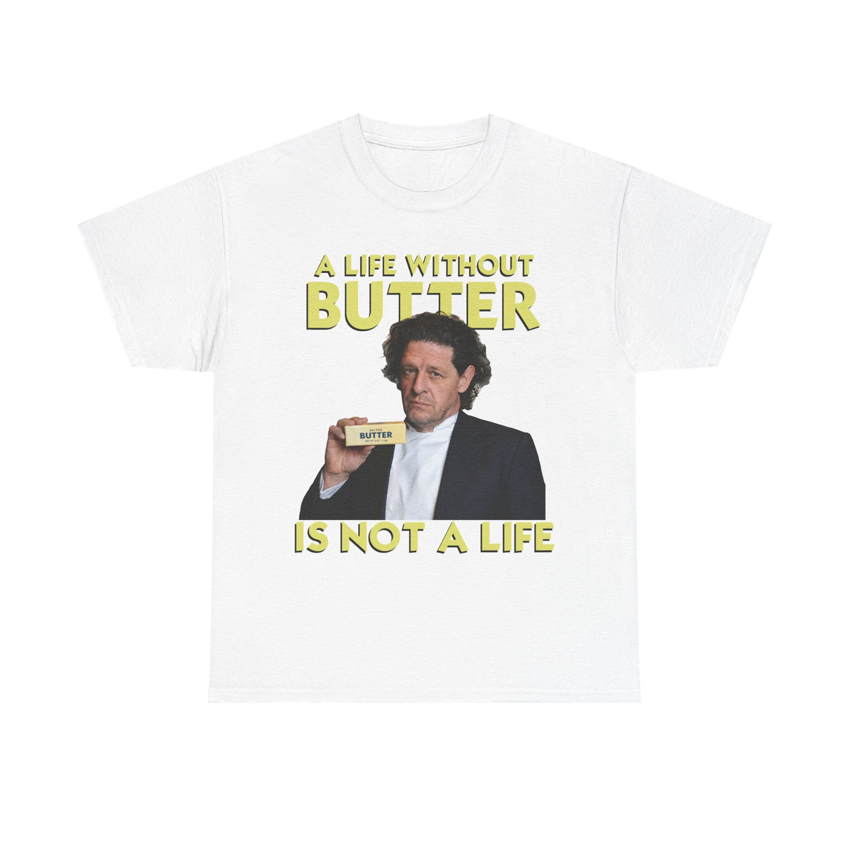 A white short-sleeve crewneck t-shirt featuring a graphic print of legendary British chef Marco Pierre White holding a butter stick, with the text 'A LIFE WITHOUT BUTTER' above and 'IS NOT A LIFE' below in yellow lettering.